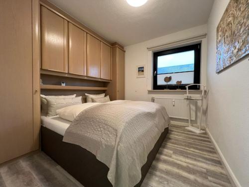 ein Schlafzimmer mit einem großen Bett und einem Fenster in der Unterkunft Margaritenhaus Heinze in Westerland