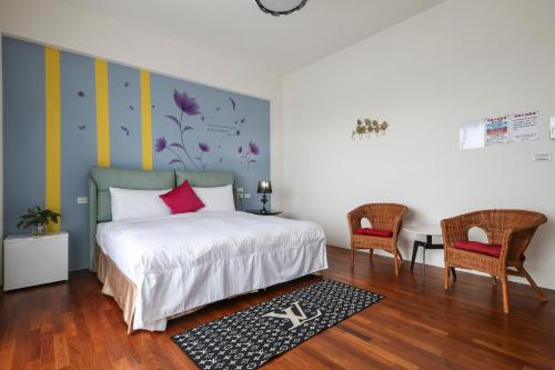 a bedroom with a bed and two chairs at Enjoy the Lift in Ch'ing-shui