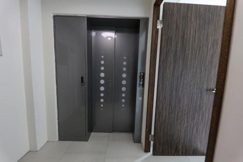 a gray elevator door in a room with a tile floor at Enjoy the Lift in Ch'ing-shui
