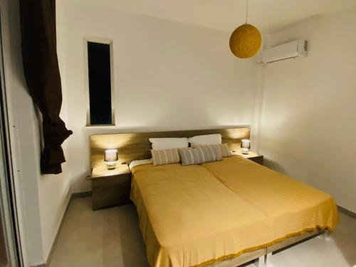 a small bedroom with a bed and two night stands at Marmaraki Village House & Apartments in Kardamaina