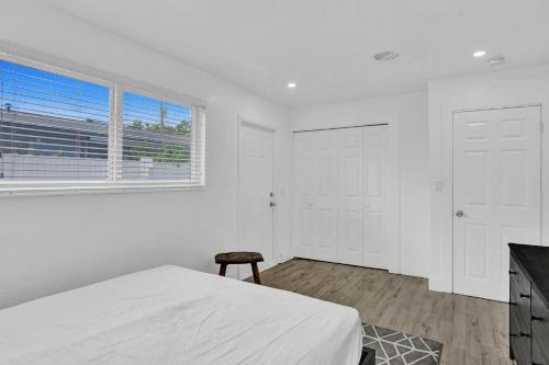 um quarto branco com uma cama e uma janela em CryptoCabana em Miami