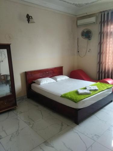 een slaapkamer met een bed in een kamer met een spiegel bij Happy Hotel Binh Chanh in Bình Chánh