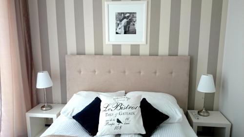 グディニャにあるWilla Długa No. 4 Bed & Breakfastのベッドルーム1室(ベッド1台、ナイトスタンド2台、ランプ2つ付)