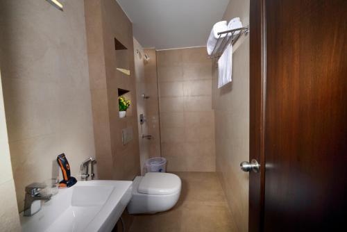 a bathroom with a white toilet and a sink at HOTEL THE FORTUNE in Coimbatore