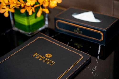 two boxes sitting on a table with a vase of flowers at OCEAN HOTEL in Phnom Penh