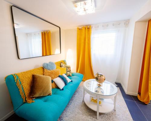 ein Wohnzimmer mit einem blauen Sofa und einem Glastisch in der Unterkunft Lodges Basel Euro Airport in Blotzheim
