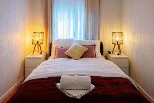 a white bed with a white comforter and pillows at Lodges Basel Euro Airport in Blotzheim