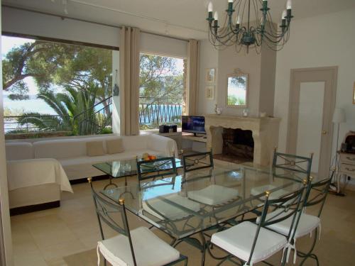 un salon avec une table en verre et des chaises dans l'établissement Farniente, au Lavandou