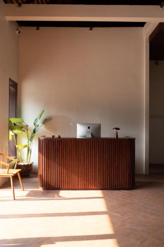 a wooden counter in a room with a laptop on a wall at Le Sen Boutique Hotel in Luang Prabang