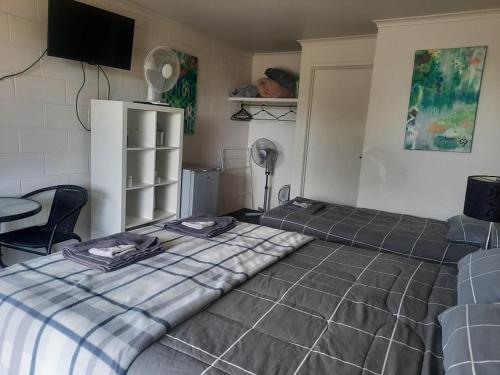a bedroom with two beds and a table and a tv at Neerim South Hotel in Neerim South