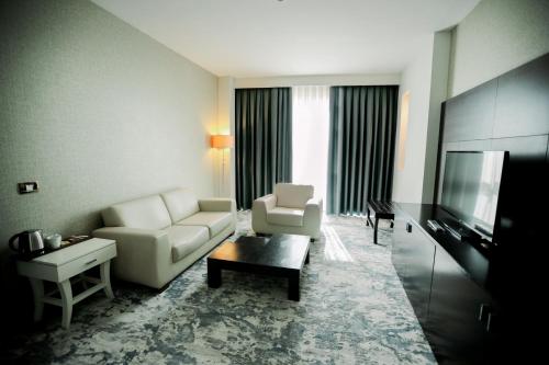 a living room with a couch and a television at Baia Bursa Hotel in Bursa