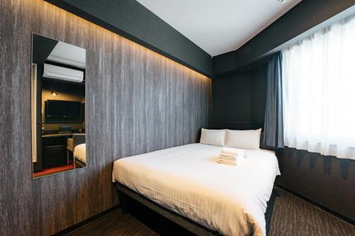 a bedroom with a bed and a mirror at mizuka Business Canal City Hakatamae in Fukuoka