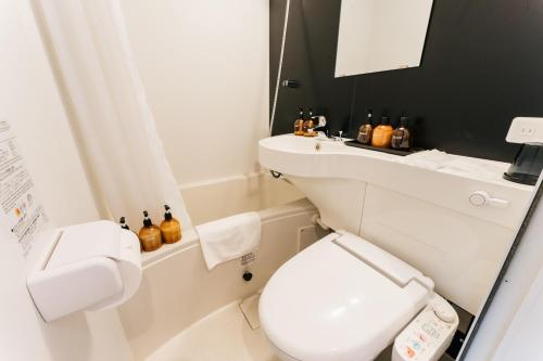 a bathroom with a white toilet and a sink at mizuka Business Canal City Hakatamae in Fukuoka