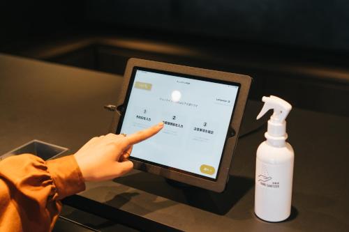 a person pointing at a tablet with a bottle of soap at mizuka Business Canal City Hakatamae in Fukuoka