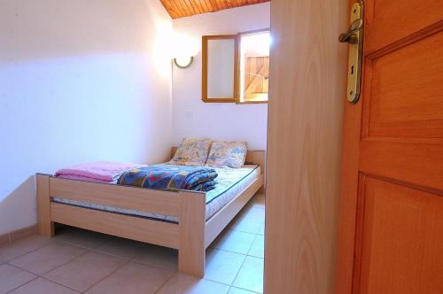 a small bed in a room with a window at 4 people apartment 350 m from the sea in Casaglione