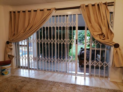 um portão de ferro com cortinas numa sala de estar em Friends Place em Joanesburgo
