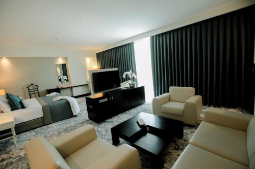 a hotel room with a bed and a living room at Baia Bursa Hotel in Bursa