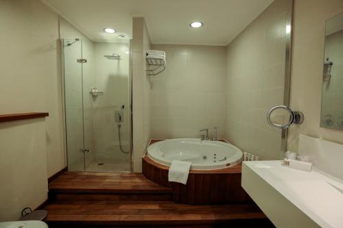 a bathroom with a tub and a shower and a sink at Baia Bursa Hotel in Bursa