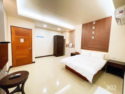 a bedroom with a bed and a desk and a chair at 花見你民宿-近東大門夜市 in Hualien City