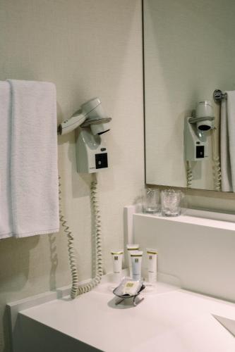 a bathroom with a sink with a phone on it at Baia Bursa Hotel in Bursa