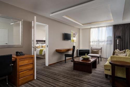 a hotel suite with a living room and a bedroom at Premier Hotel Midrand in Midrand