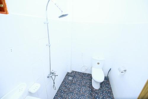 a white bathroom with a toilet and a sink at Nature Relax in Ella