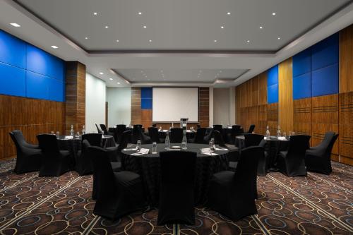 a conference room with tables and chairs and a whiteboard at Premier Hotel Midrand in Midrand