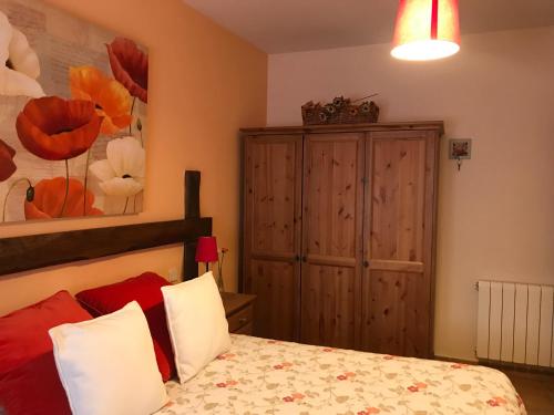 a bedroom with a bed and a wooden cabinet at La Senda Del Duratón in Sebúlcor