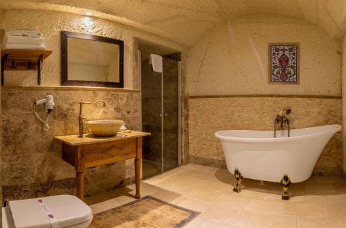 a bathroom with a tub and a sink and a toilet at Seki Cave Suites in Goreme