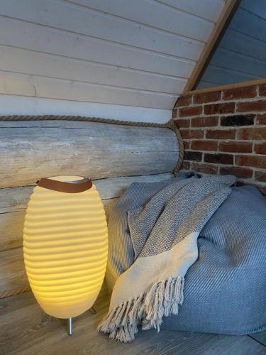 a yellow vase sitting next to a brick wall at Nordicstay Noarootsi Saunahouse in Paslepa