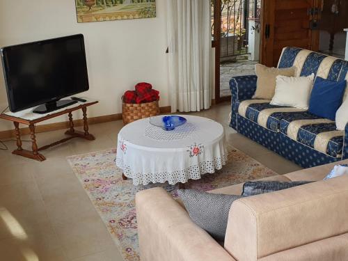 a living room with a couch and a tv and a table at Casa Vista Lago 154 SQM in Passignano sul Trasimeno