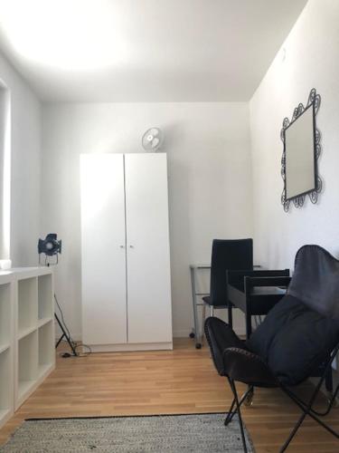 a living room with two chairs and a mirror at La Maison des Copains in Blonay