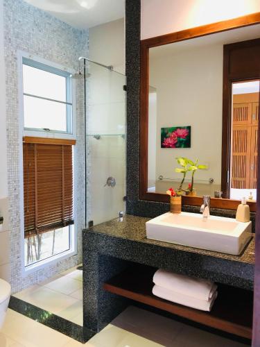 a bathroom with a large mirror and a sink at Samui Blu, villa with private pool in Choeng Mon Beach