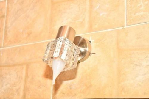 a shower head on a wall with diamonds on it at Om-Abdallah in Aswan