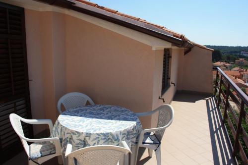 a table and chairs on the balcony of a house at Family Friendly Apartments in Pula