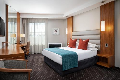 a hotel room with a bed and a desk at Premier Hotel O.R. Tambo in Kempton Park