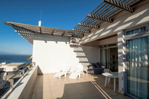 a balcony with chairs and a view of the ocean at The Square 10 in Plettenberg Bay
