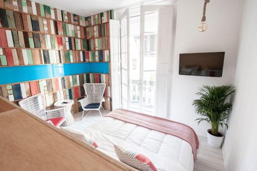 a bedroom with a bed and a wall of books at Urban Suite Santander in Santander