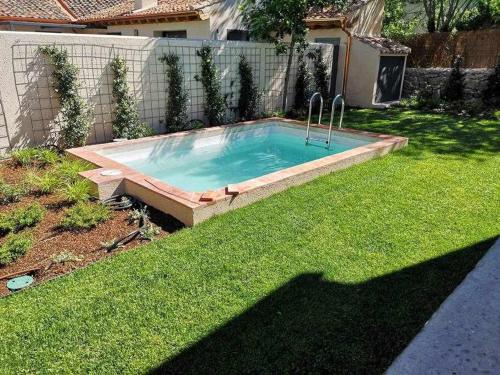 a small swimming pool in a yard with grass at La Alberca Casa con jardín y piscina in Tenzuela