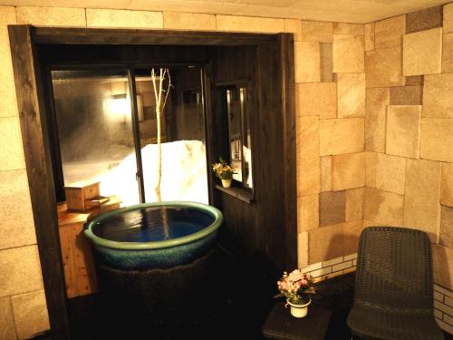a bathroom with a large tub in a room at Ougiya Ryokan in Hakuba