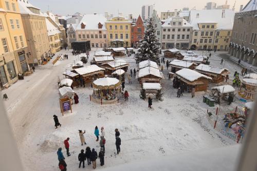 a group of people walking around a christmas market at Historic Residence Apartments at Old Town in Tallinn