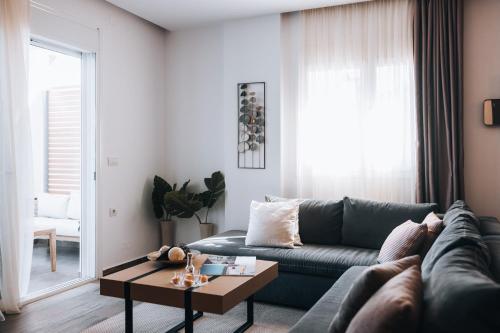 a living room with a blue couch and a coffee table at Seascape Luxury Residences in Agia Pelagia