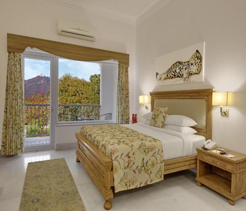 a bedroom with a bed and a large window at Fateh Garh Resort by Fateh Collection in Udaipur