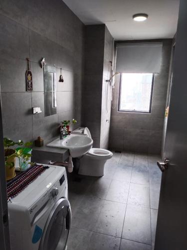 a bathroom with a toilet and a sink and a washing machine at Usj One Residence @ Homestay in Subang Jaya
