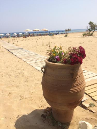 a large flower pot on the beach with umbrellas at Arbutus - Relaxing apartment with Fantastic Views in Georgioupolis