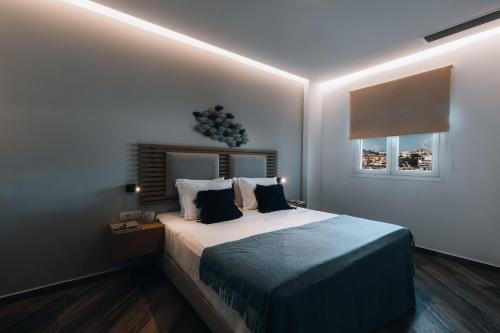 a bedroom with a bed and two windows at Seascape Luxury Residences in Agia Pelagia