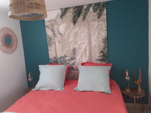 une chambre avec un lit avec des oreillers rouges et blancs dans l'établissement Le petit atelier, à Bormes-les-Mimosas