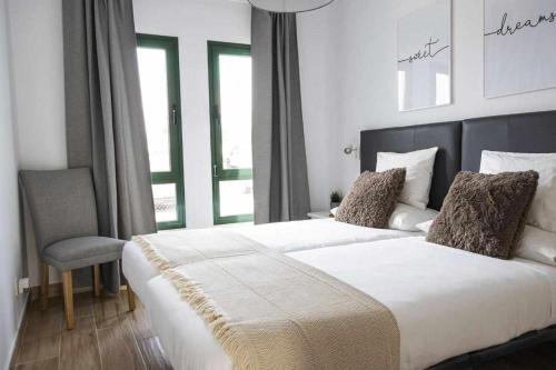 1 dormitorio con 1 cama grande y 1 silla en Holyhome premium 112 en Costa Teguise