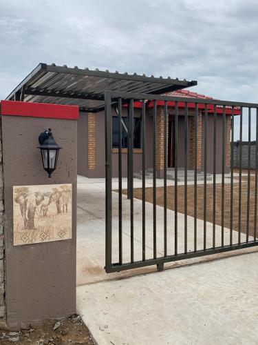 a building with a gate and a sign in front of it at Elephant House, 2 bedroom House, Next to Pilanesberg and Sun City in Mogwase