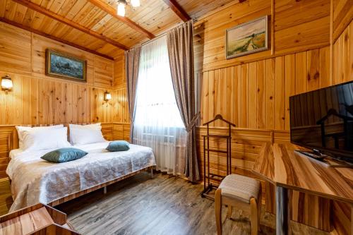 a bedroom with a bed and a television in a room at Emerald House in Mykulychyn